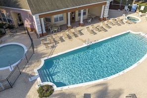 A swimming pool with lounge chairs and a covered seating area.