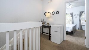 A bedroom with a bed, a desk, a chair, a small cabinet, and a white radiator. - Recently renovated townhome near Theme Parks (Kissimmee)