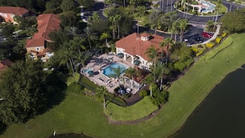 Vista aérea de una zona residencial con piscina, varias casas y una red de carreteras.