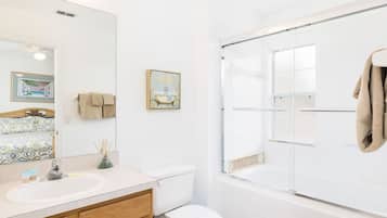 A bathroom with a shower, toilet, and sink.
