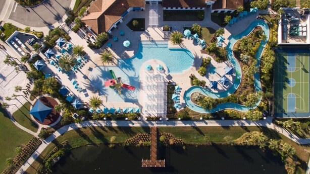 An aerial view of a resort with a swimming pool, a water slide, and a tennis court. - SpaciousTownhome 15 min to Disney Private Pool-BBQ (Kissimmee)