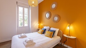 Une chambre d’hôtel avec un grand lit, des lampes de chevet, une fenêtre et des éléments de décoration murale.