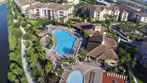 A resort with a large central pool, multiple smaller pools, and a variety of outdoor seating areas.
