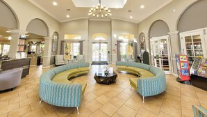 A spacious lobby with a central seating area, a chandelier, and a reception desk. - Spacious Condo 5min to Universal and Conv Center (Orlando)