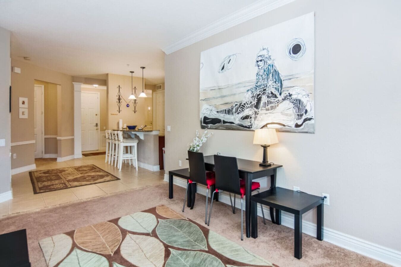 Un coin repas avec une table, des chaises et un tableau accroché au mur.