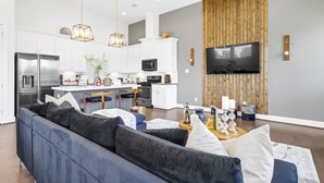 A modern kitchen with white cabinets, stainless steel appliances, and a central island. - Spacious 3BR Houston Escape near Downtown with Spa (Houston)