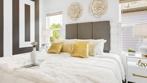 A bedroom with a large bed, a nightstand, a dresser, and decorative wall art. - Spacious 3BR Houston Escape near Downtown with Spa (Houston)