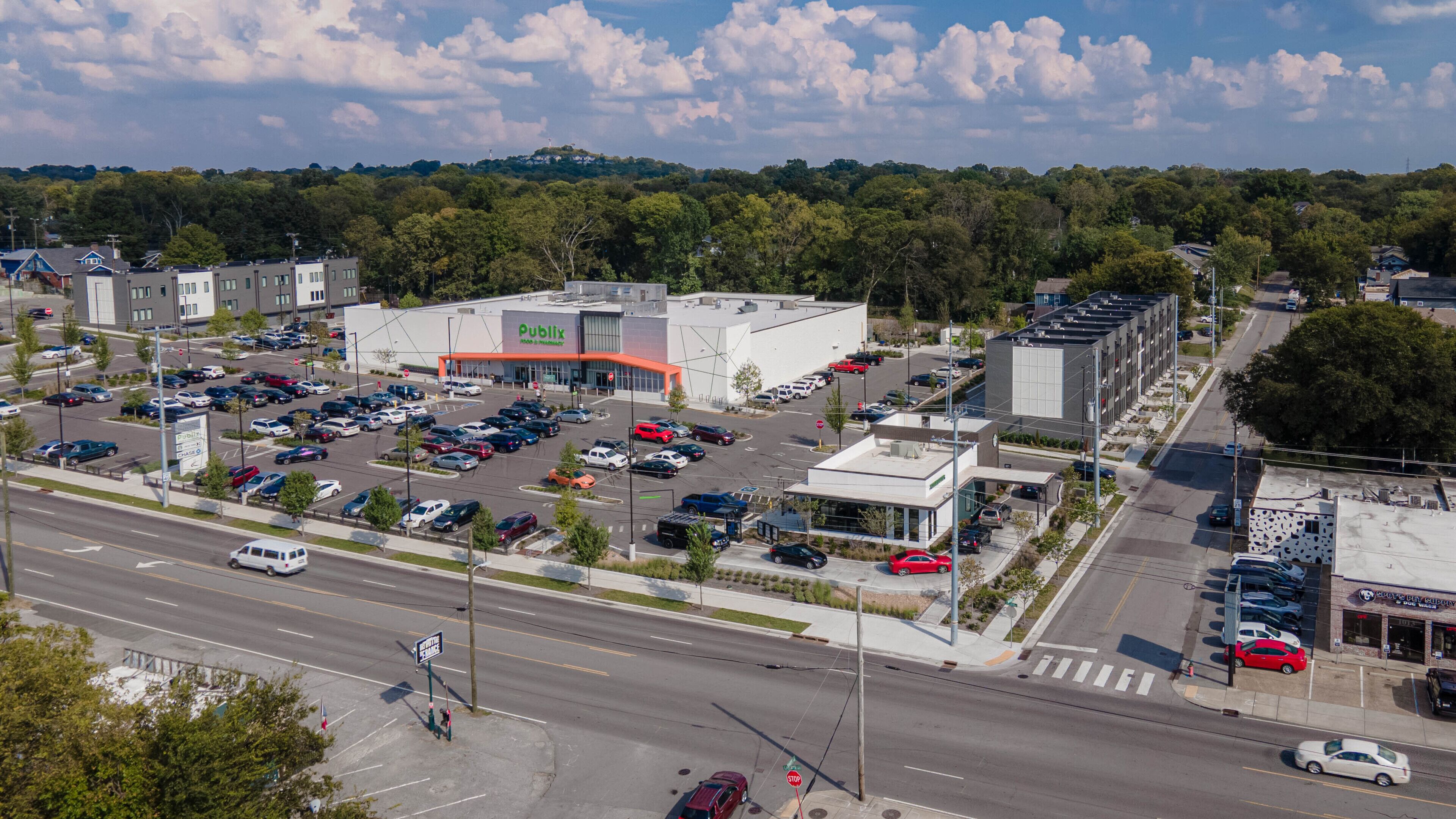 Zona comercial con una tienda Publix, estacionamientos y una intersección de calles.
