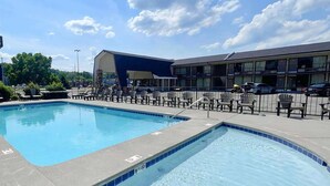 A swimming pool with lounge chairs and a building in the background.