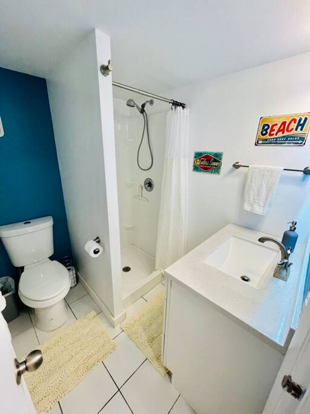 Une salle de bain équipée de toilettes, d’une douche, d’un lavabo et d’un porte-serviettes.