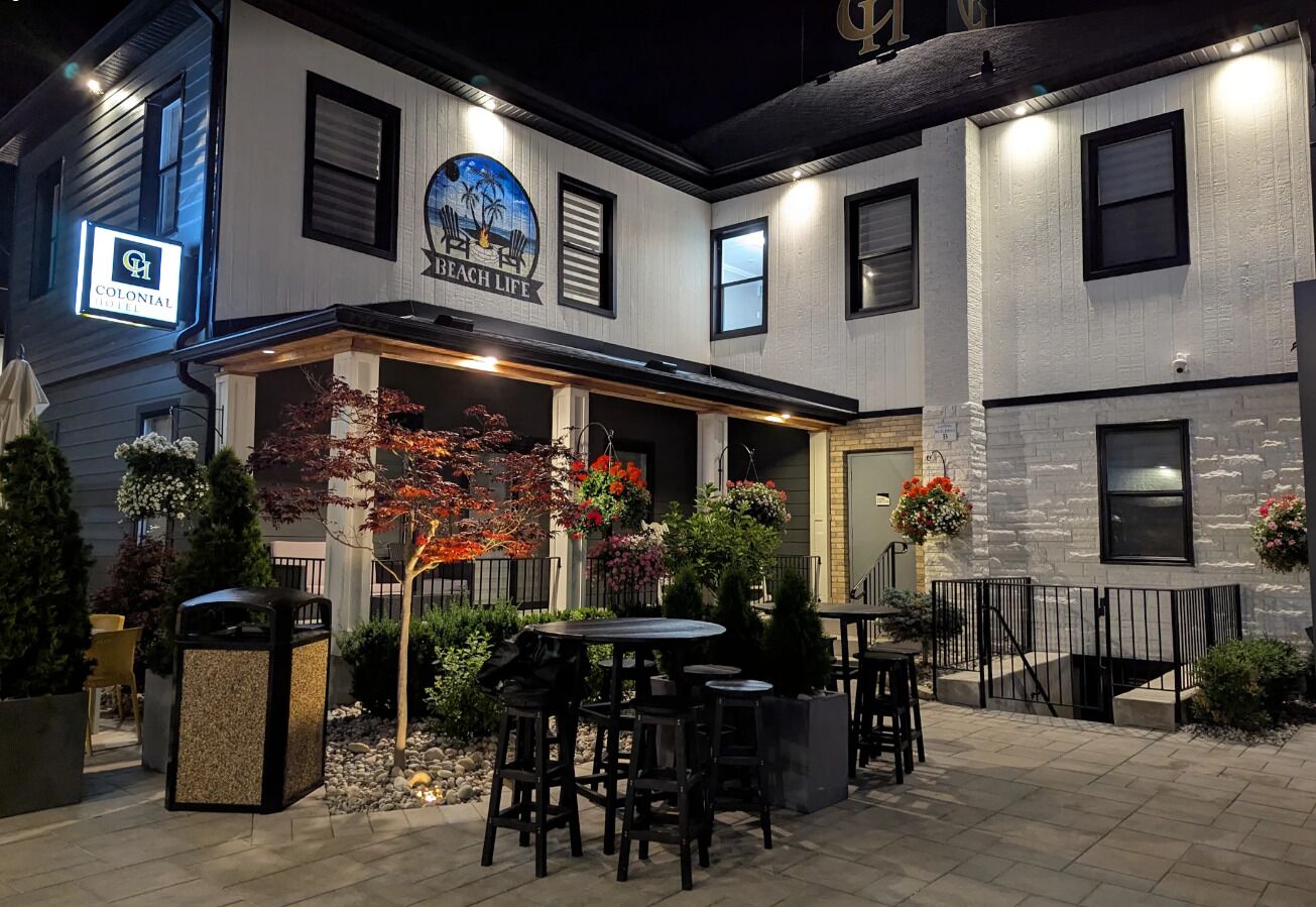 A Colonial Beach Life hotel with outdoor seating and a well-lit patio area.