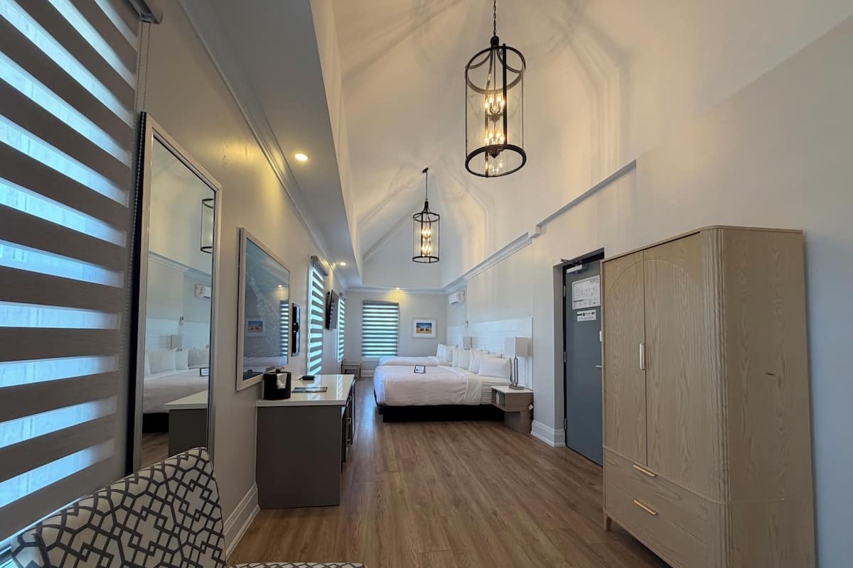 Une chambre d’hôtel comprenant un lit, des tables de chevet, une armoire, un bureau et une chaise.