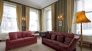 A room with two sofas, a floor lamp, and patterned wallpaper. - Quirky, West End, Georgian Apartment (Edinburgh)