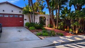 A residential house with a red garage door, a driveway, and a street number 22562. - Gated Hacienda Retreat •Large Pool & Spa •Pet Friendly• Near Beaches & SeaWorld (San Diego)