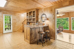 Enjoy cooking in this kitchen with a central island and stools, offering a view of the outdoors.