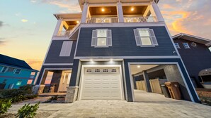 A two-story house with a garage, a balcony on the upper floor, and a driveway leading to the entrance. - Spectacular Ocean Front home (Flagler Beach)