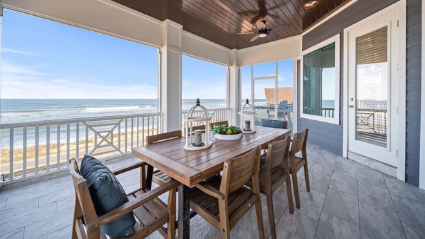 A wooden deck with a table and chairs, overlooking the ocean. - Spectacular Ocean Front home (Flagler Beach)