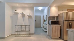 Une cuisine moderne dotée d’appareils électroménagers en acier inoxydable, de meubles blancs et d’un design minimaliste.