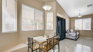 A spacious room with a dining table, chairs, a bench, and a bed. - Clean, Convenient & Comfortable Vegas House (Las Vegas)