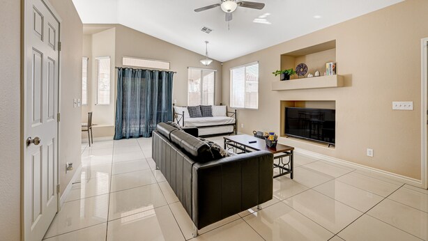 A modern living room with a sofa, a coffee table, a TV, and a fireplace. - Clean, Convenient & Comfortable Vegas House (Las Vegas)
