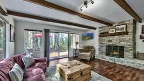 Una sala de estar con chimenea de piedra, un sofá de cuero rojo y una mesa de centro de madera.