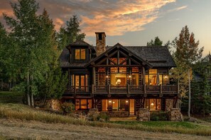 A large, multi-story log cabin with a prominent balcony and stone chimney. - Skywatch Lodge - ski in/out BC, hot tub, sleeps 12 (Avon)
