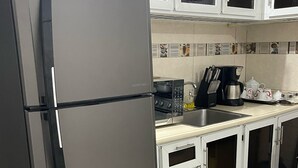 A kitchen with a stainless steel refrigerator, white cabinets, a coffee maker, and a sink. - Marant's Lodge #2 (Puerto Plata)