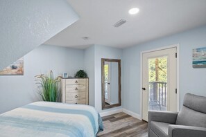 A bedroom with a bed, dresser, mirror, and a door leading to a balcony. - Holiday Shores 23 - Three Bedroom Villa, Sleeps 8 (Osage Beach)