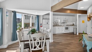 A modern kitchen with white cabinets, a microwave, and a stove.