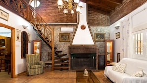 Amplia sala de estar con chimenea, una escalera y una zona de estar acogedora.