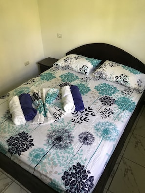 Restful retreat with a neatly made bed and floral-patterned bedding.
