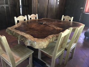 Enjoy meals around a round dining table surrounded by six chairs in a rustic interior.