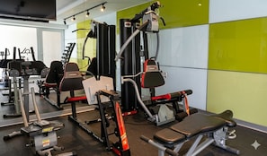 A gym with various exercise equipment, including weight machines and benches.