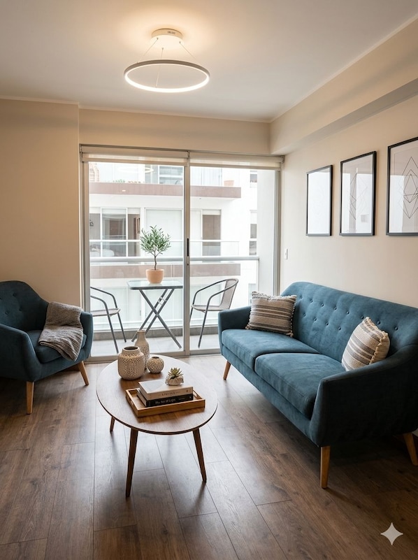 A modern living room with a blue sofa, two armchairs, a coffee table, and a potted plant.