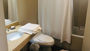 Et badeværelse med vask, toilet og bruseområde.