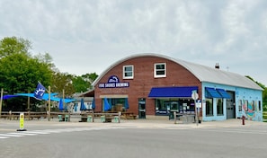 A brick building with a blue awning labeled "Five Shores Brewing."