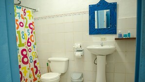 A bathroom with a toilet, sink, and shower curtain with numbers. - Private Villa, front yard (Punta Uva)
