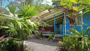 A covered outdoor area with a gravel path leading to a blue and white structure. - Private Villa, front yard (Punta Uva)