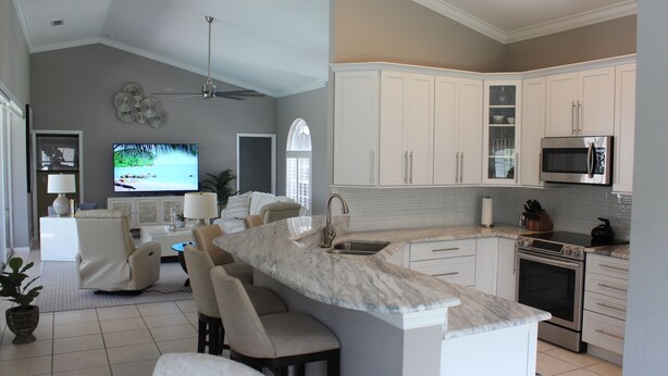 A modern kitchen with white cabinets, a marble countertop, and a built-in oven. - Naples- Briarwood Estates all new 4BR/3 BA, sleeps 10, vacation rental (Naples)