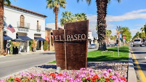 A sign with "EL PASO" written on it, surrounded by colorful flowers and palm trees. - Gorgeous getaway near El Paseo!  Huge property with huge pool. Tesla charger! (Palm Desert)