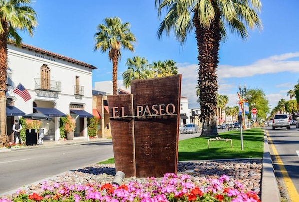 Un panneau sur lequel est écrit « EL PASO », entouré de fleurs aux couleurs vives et de palmiers.