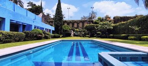 Relax by the hotel's inviting pool surrounded by lush greenery and beautifully trimmed hedges.