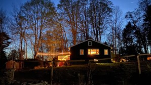 A house with a dark exterior, surrounded by trees and a fence. - Blue House in Smallwood NY, Year round, 2-bed in Catskill Mts (Monticello)