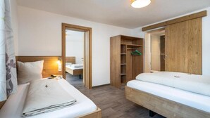Ein Schlafzimmer mit zwei Betten, einem Holzschrank und einem Spiegel.