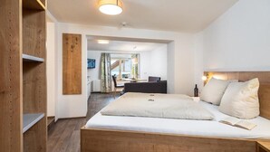 Una habitación de hotel moderna con una cama de madera, un escritorio y vistas al exterior.