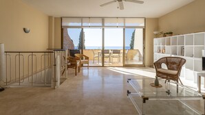 A spacious room with a balcony, a ceiling fan, and a large window offering a view of the sea. - "Los Girasoles" Apartment with Sea View, Wi-Fi, and Terrace (La Herradura)