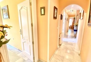A hallway with a white door, a radiator, and framed pictures on the walls. - Apartment "Oasis" Near the Beach with Sea View, Pool, Wi-Fi & Terrace (La Herradura)