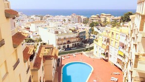 A residential area with a swimming pool, buildings with balconies, and a view of the sea. - "Oasis" Apartment near the Beach with Sea View, Pool, Wi-Fi, and Terrace (La Herradura)