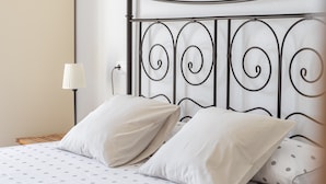 A bed with a metal headboard, two pillows, a lamp, and a bedside table. - Apartment "Brisa de mar" Near the Beach with Sea View, Pool & Terrace (La Herradura)