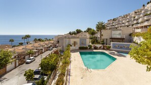 A residential area with a swimming pool, a view of the sea, and a street with parked cars. - Apartment "Brisa de mar" Near the Beach with Sea View, Pool & Terrace (La Herradura)